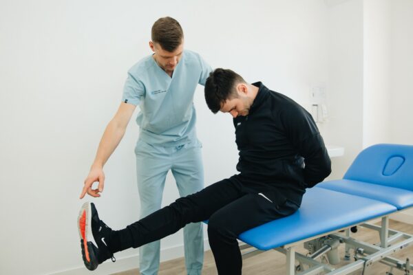 Physical therapist performing a straight-leg-raise exam — sciatica assessment, Saint Paul Park MN