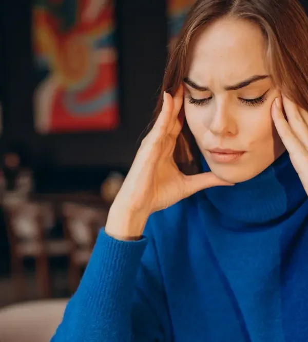 Woman holding her temples with a headache — chiropractor in Saint Paul Park, MN