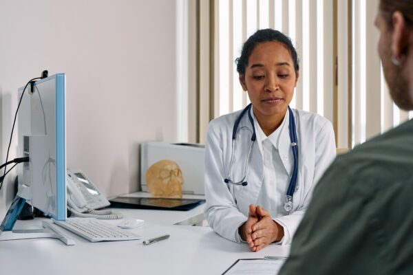 Doctor listening closely during a patient intake consultation — first chiropractic visit, Saint Paul Park MN