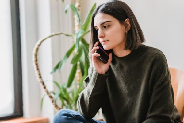 Woman thoughtfully on the phone at home — deciding on the right care, Saint Paul Park MN