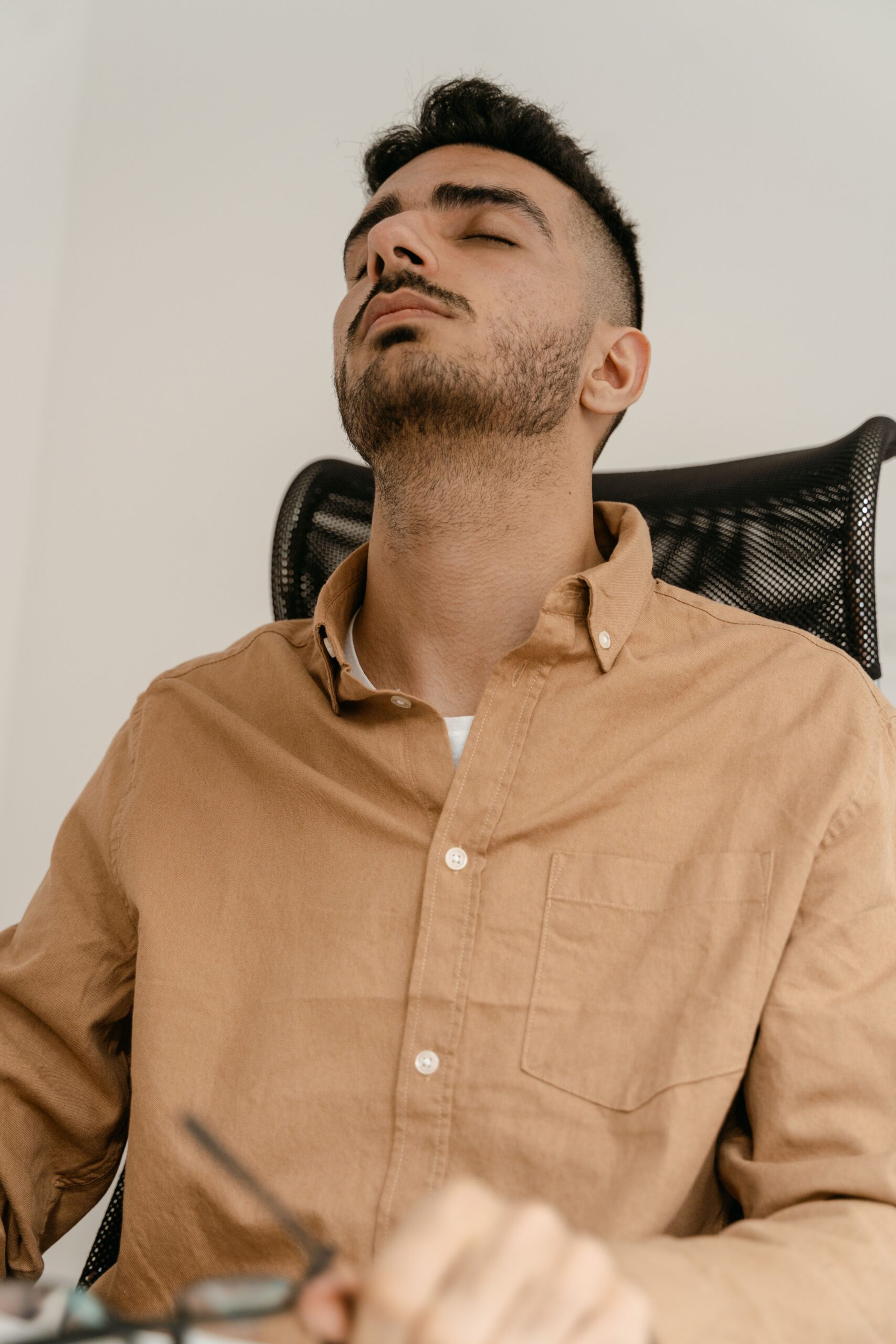 Tired office worker leaning back in a desk chair — low back pain from sitting, Saint Paul Park MN