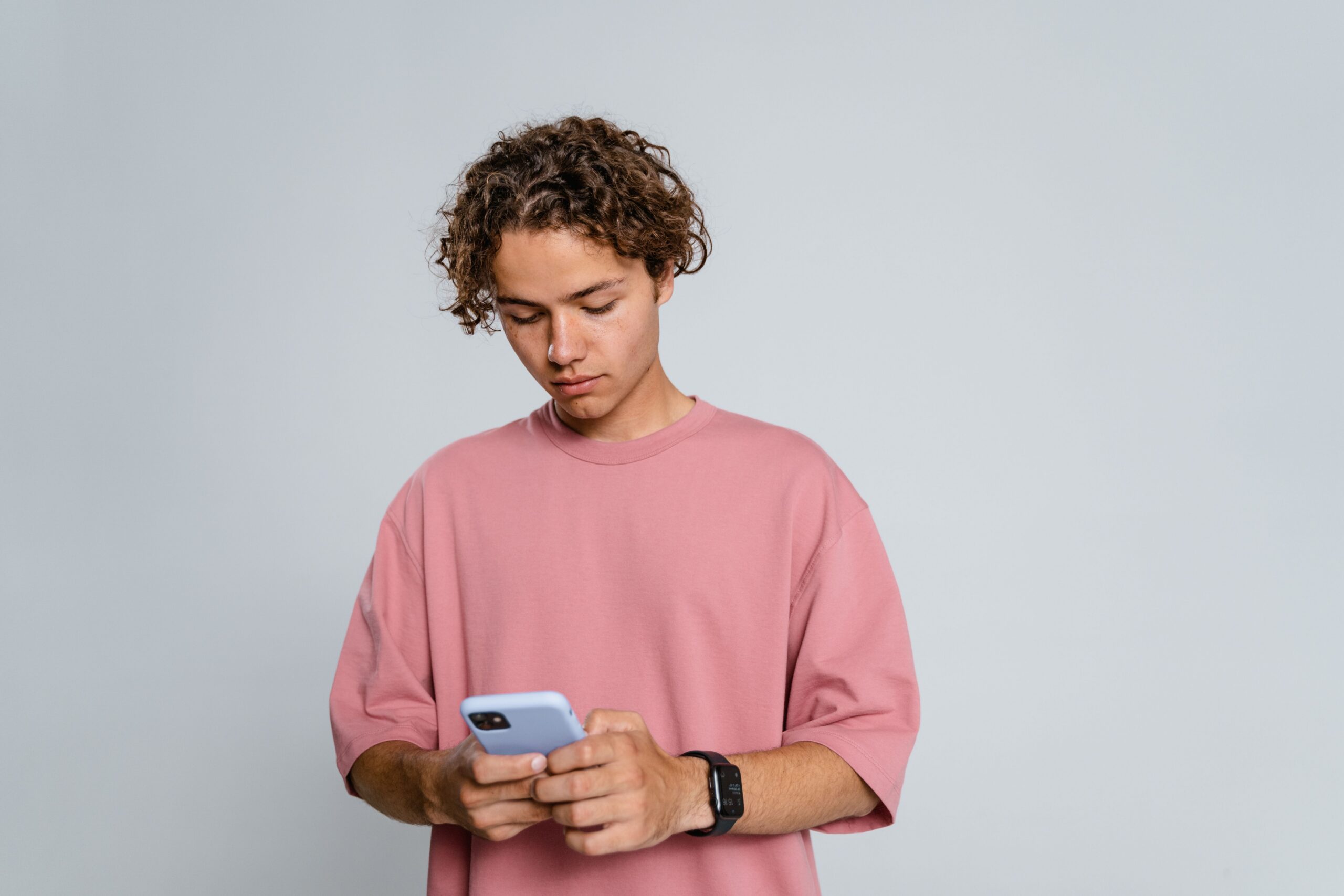 Teenager looking down at a phone with forward head posture — text neck, Saint Paul Park MN